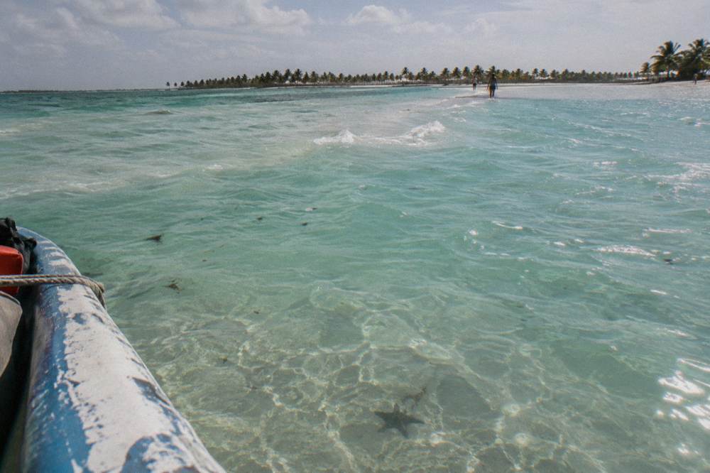 Turquoise shallows of a natural sandbar pool stretching toward the horizon