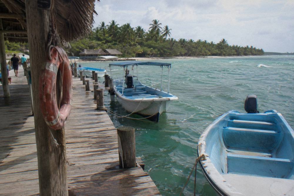 Wooden tour pier at a Caribbean fishing village with boats tied along the dock