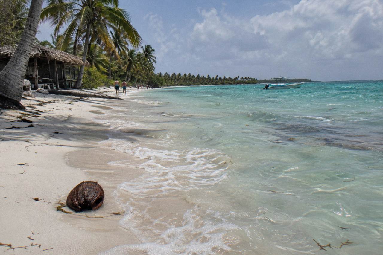 Calm turquoise shallows lapping a wide white sand beach on Saona Island