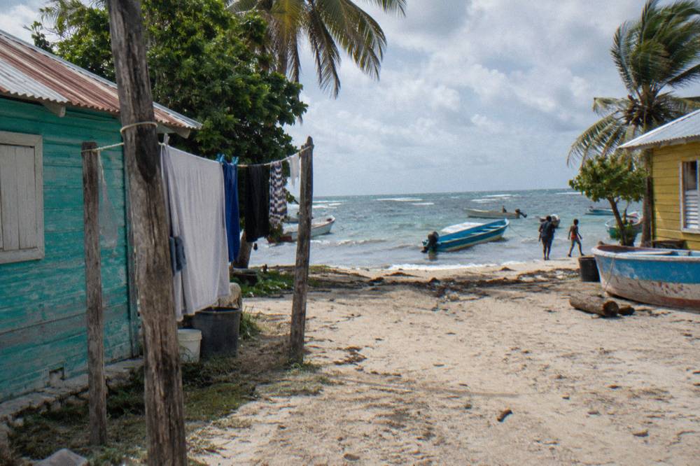 Fishing village beach with small colorful wooden houses along the sand and a few moored boats