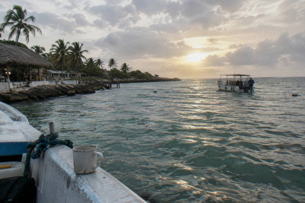 Sunrise light on a calm Caribbean bay with a dive boat heading out