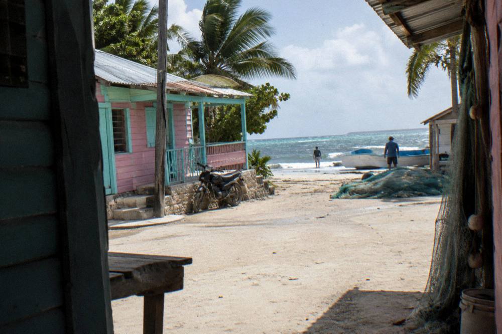A small Caribbean village street of colorful low buildings near the waterfront
