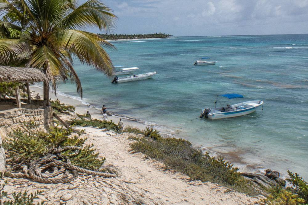Pier with excursion boats and calm Caribbean water in early morning light