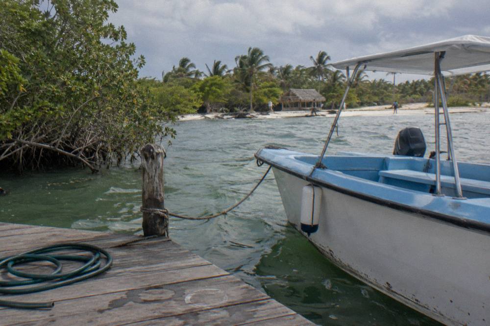 A speedboat moored at a small Caribbean dock in early morning light