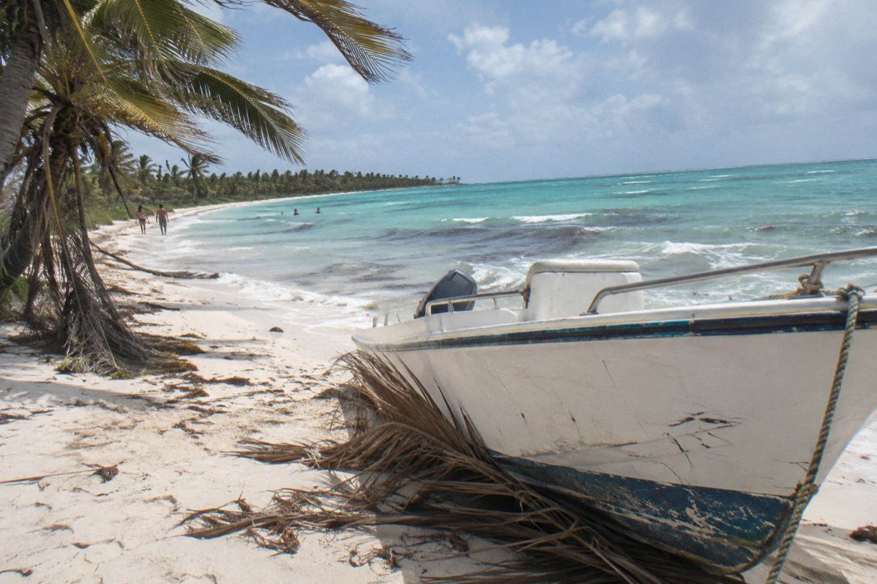 Speedboat parked on pale sand beside turquoise shallows at a Caribbean island beach
