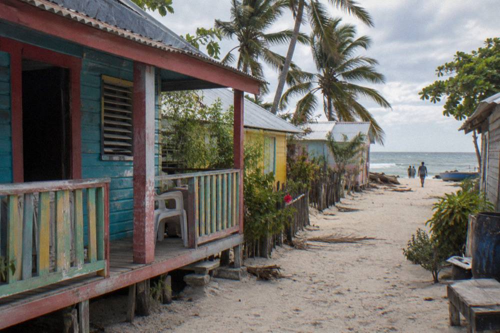 Colorful wooden houses along a sandy lane in a small Caribbean fishing village